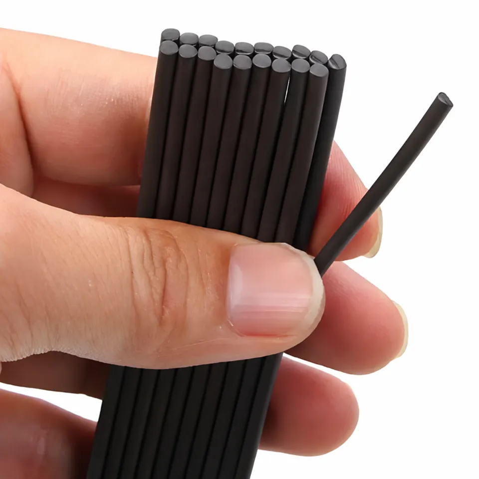 Close-up of dark round magnetic cord ends held between fingers.