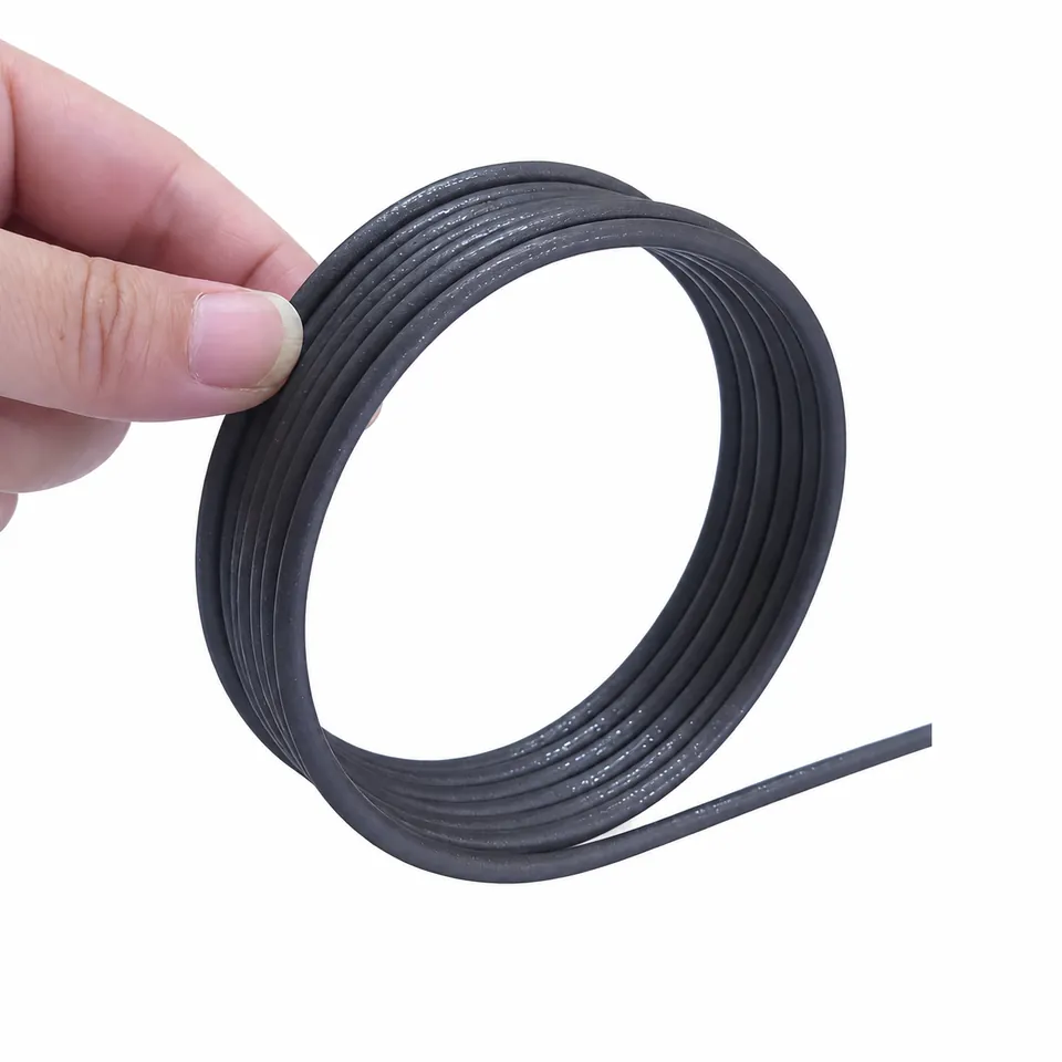A dark flexible magnetic cord coil held upright with one loose end.