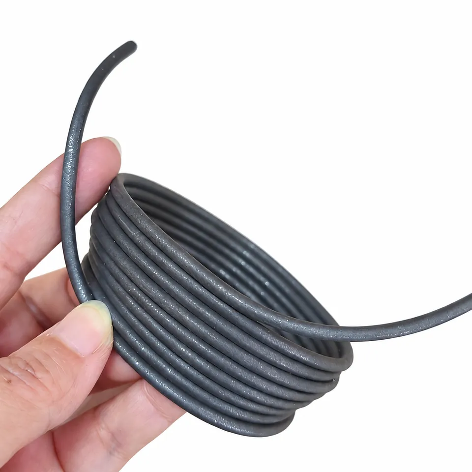 A gray flexible magnetic cord coil held in a palm with two free ends.